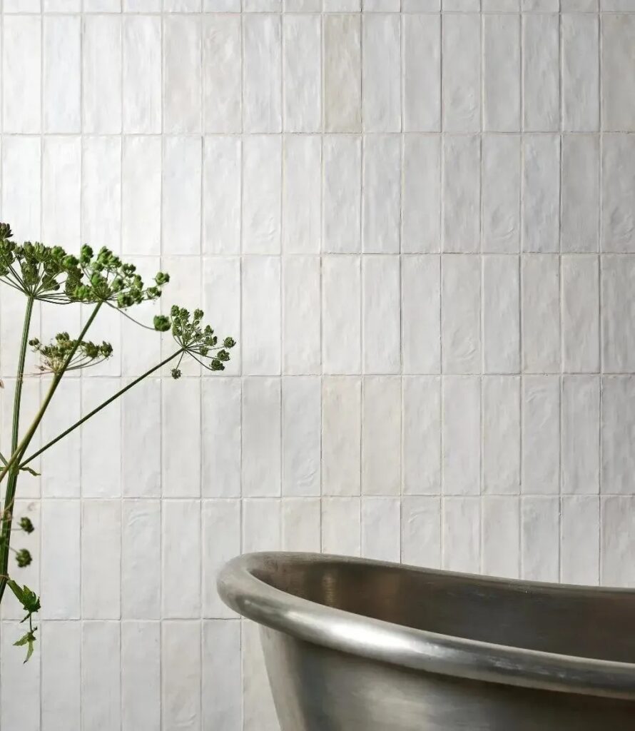 White tiled bathroom wall with copper basin